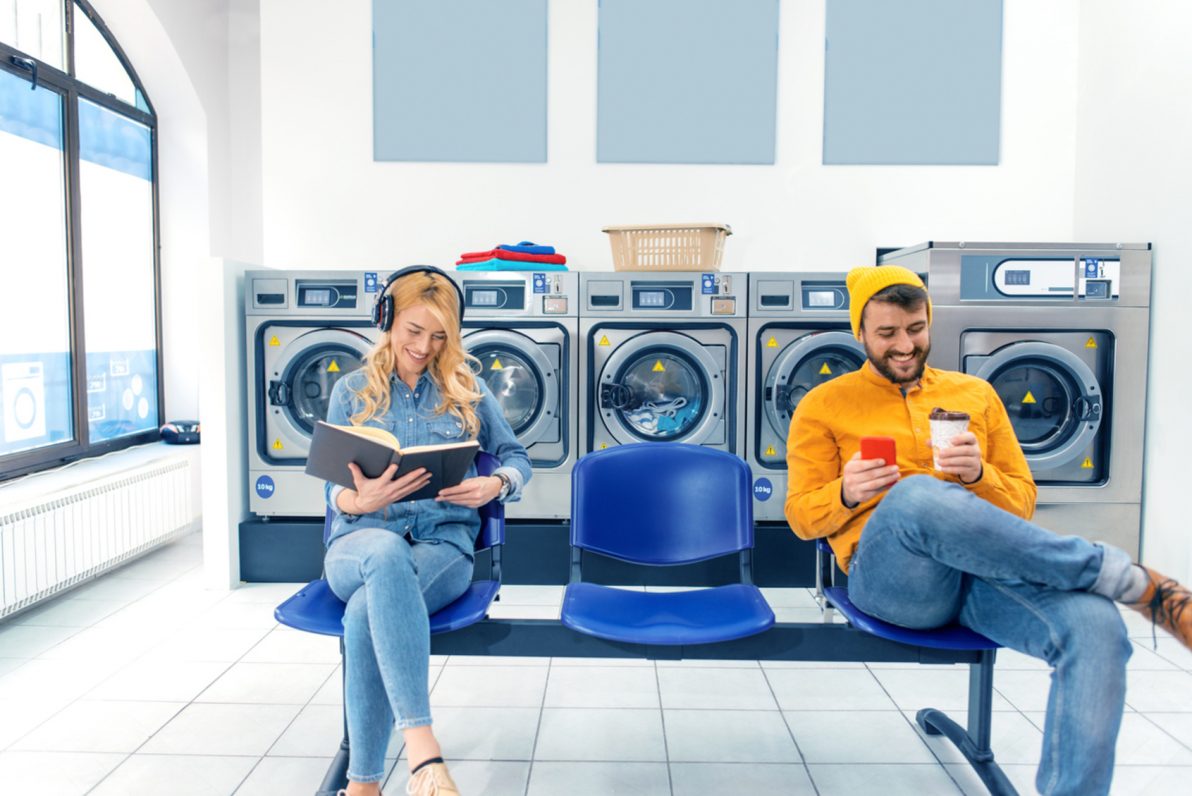 Chico y chica en el interior de una franquicia de lavandería [iStock]