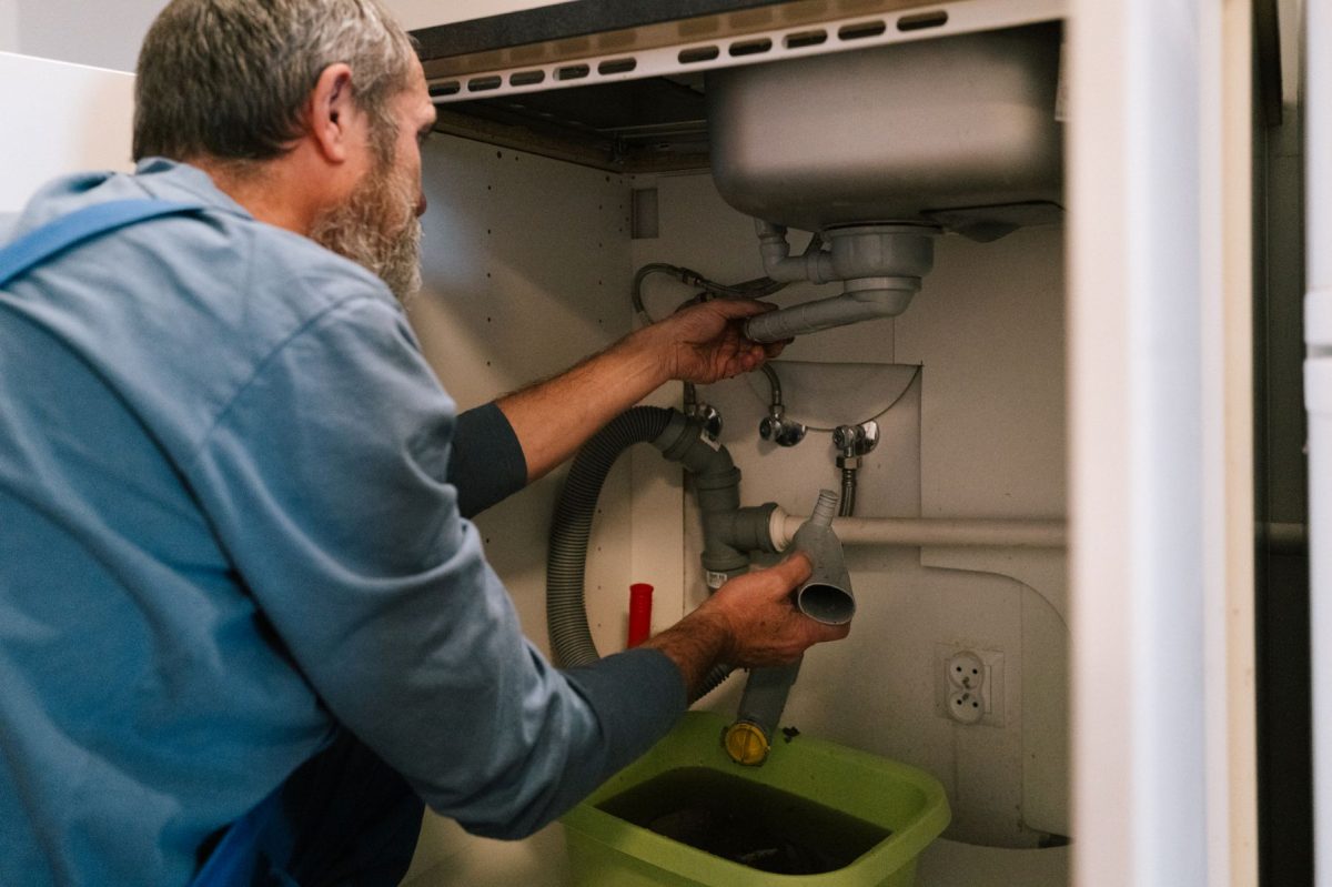 Fontanero reparando el desagüe de un fregadero