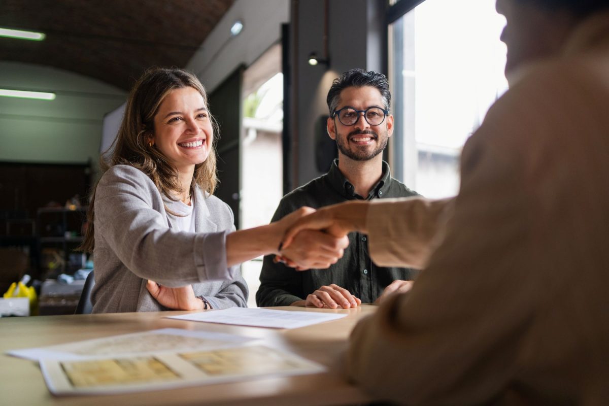 Pareja joven de emprendedores firmando un acuerdo