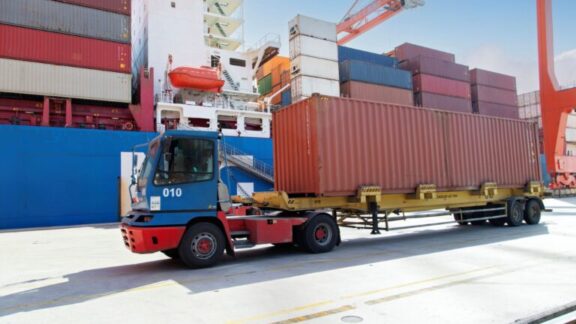 Tráiler transportando un contenedor en un puerto marítimo