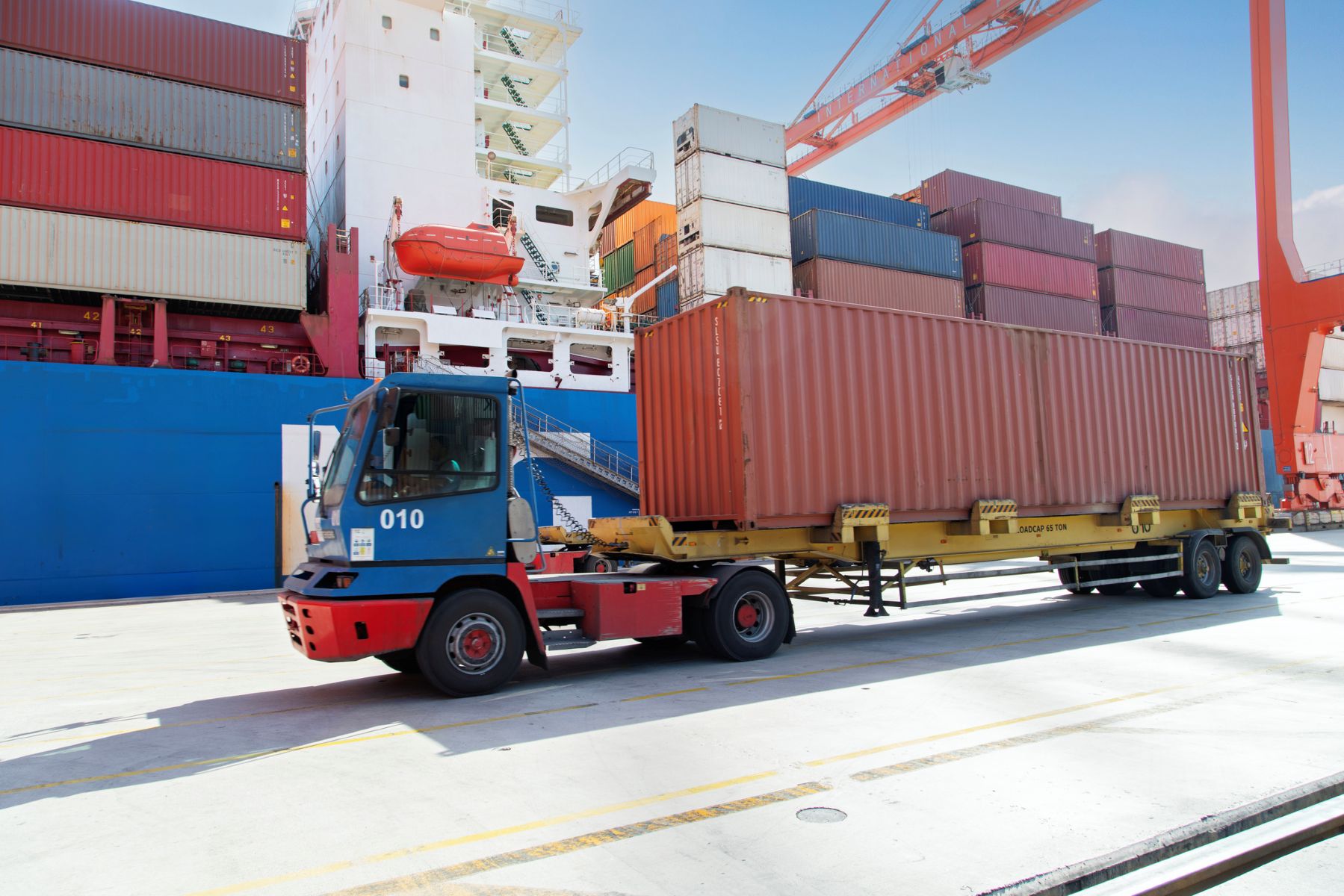 Tráiler transportando un contenedor en un puerto marítimo