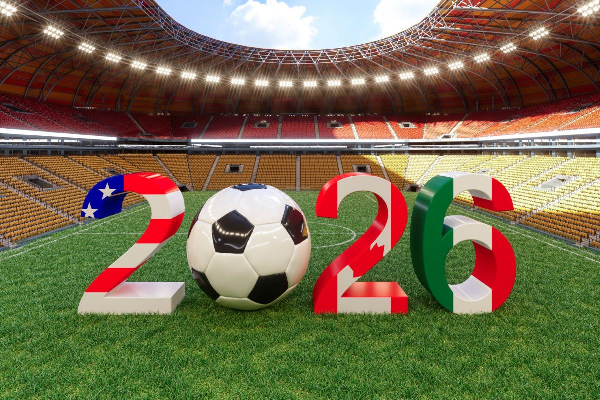 Número 2026 creado con un balón de fútbol y las banderas de los países organizadores del Mundial de fútbol sobre el césped de un estadio vacío