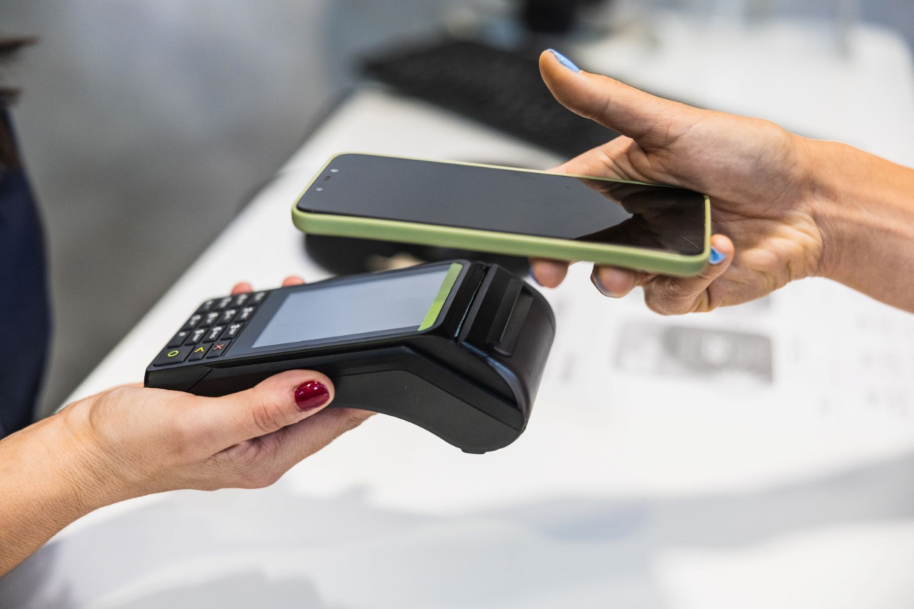 Persona que realiza pagos sin contacto con smartphone en un TPV