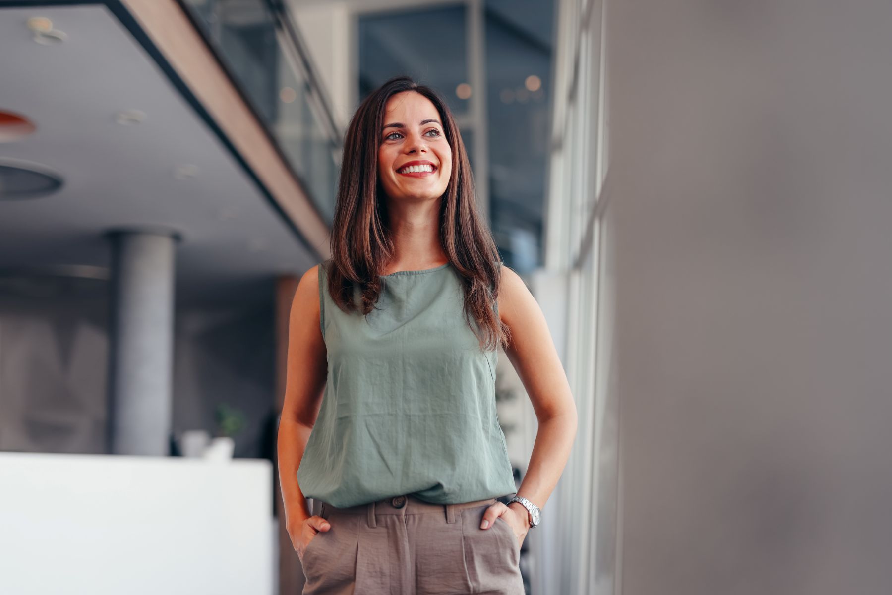 Emprendedora sonriente y contemplando el futuro con optimismo