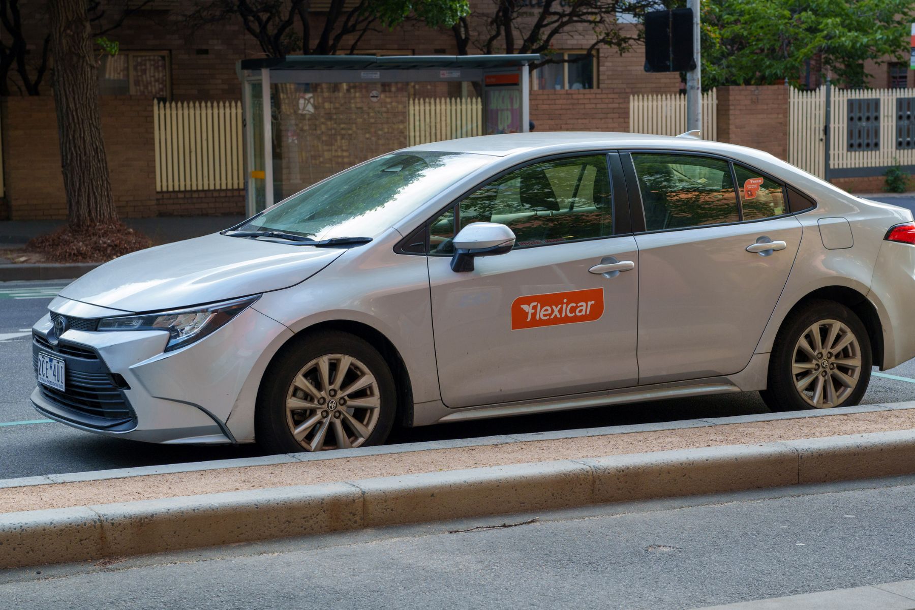Coche Flexicar plateado aparcado junto a un bordillo en una zona urbana