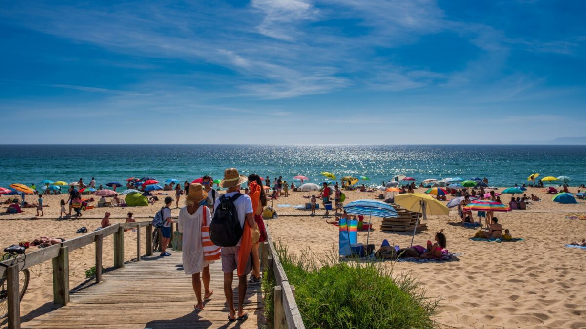 Familia que llega caminando por una pasarela a la playa