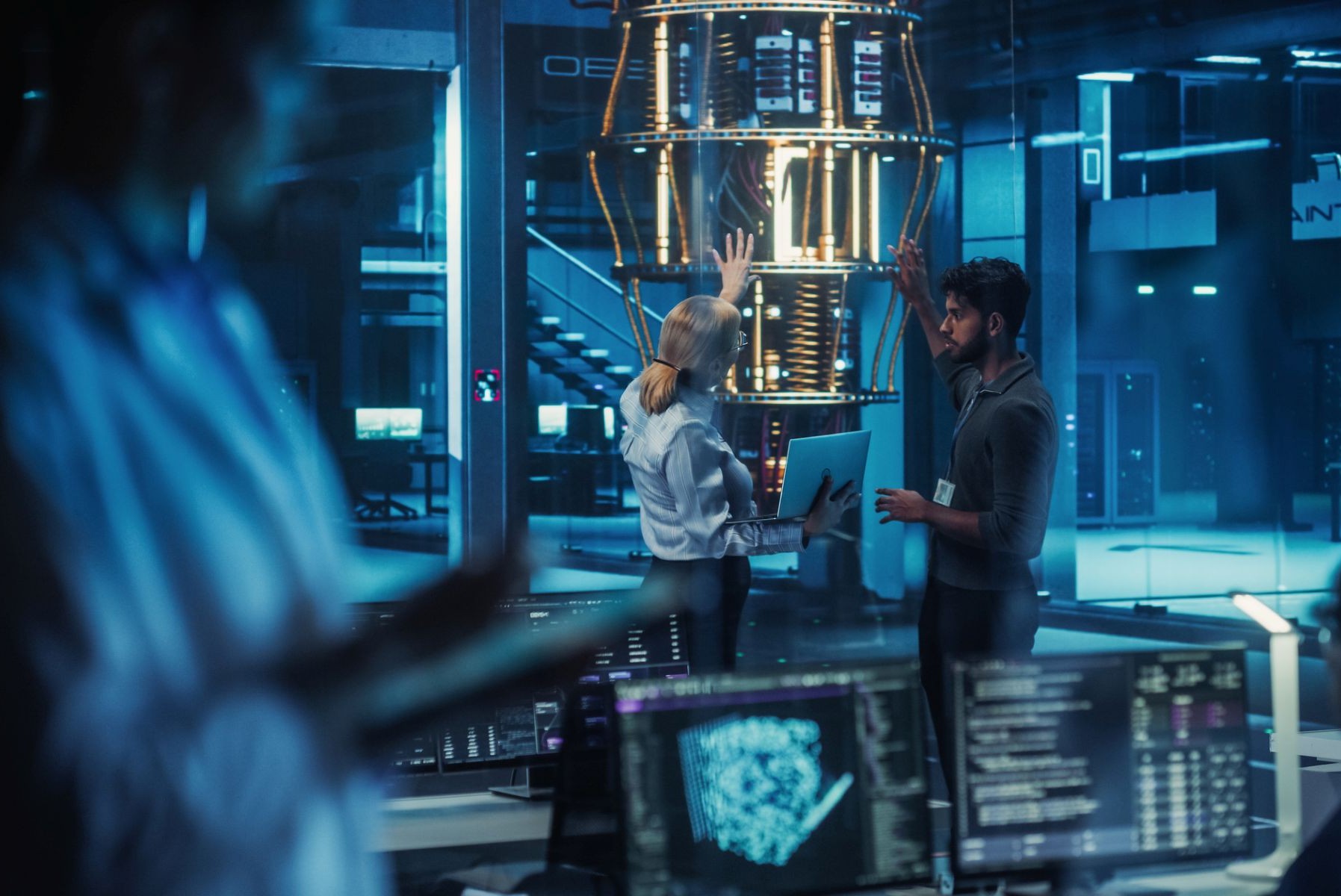 Laboratorio futurista donde varios ingenieros discuten un proyecto de computadora cuántica, analizando datos en un ordenador portátil