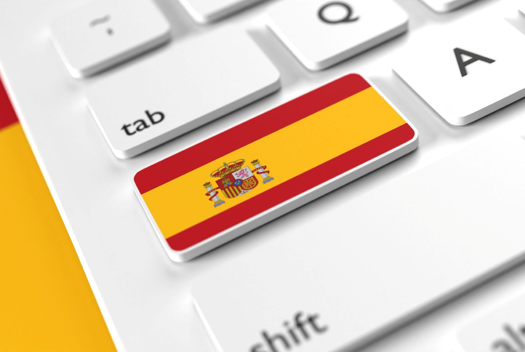 Detalle de teclado que incluye tecla con la bandera de España, sobre fondo de la bandera de España