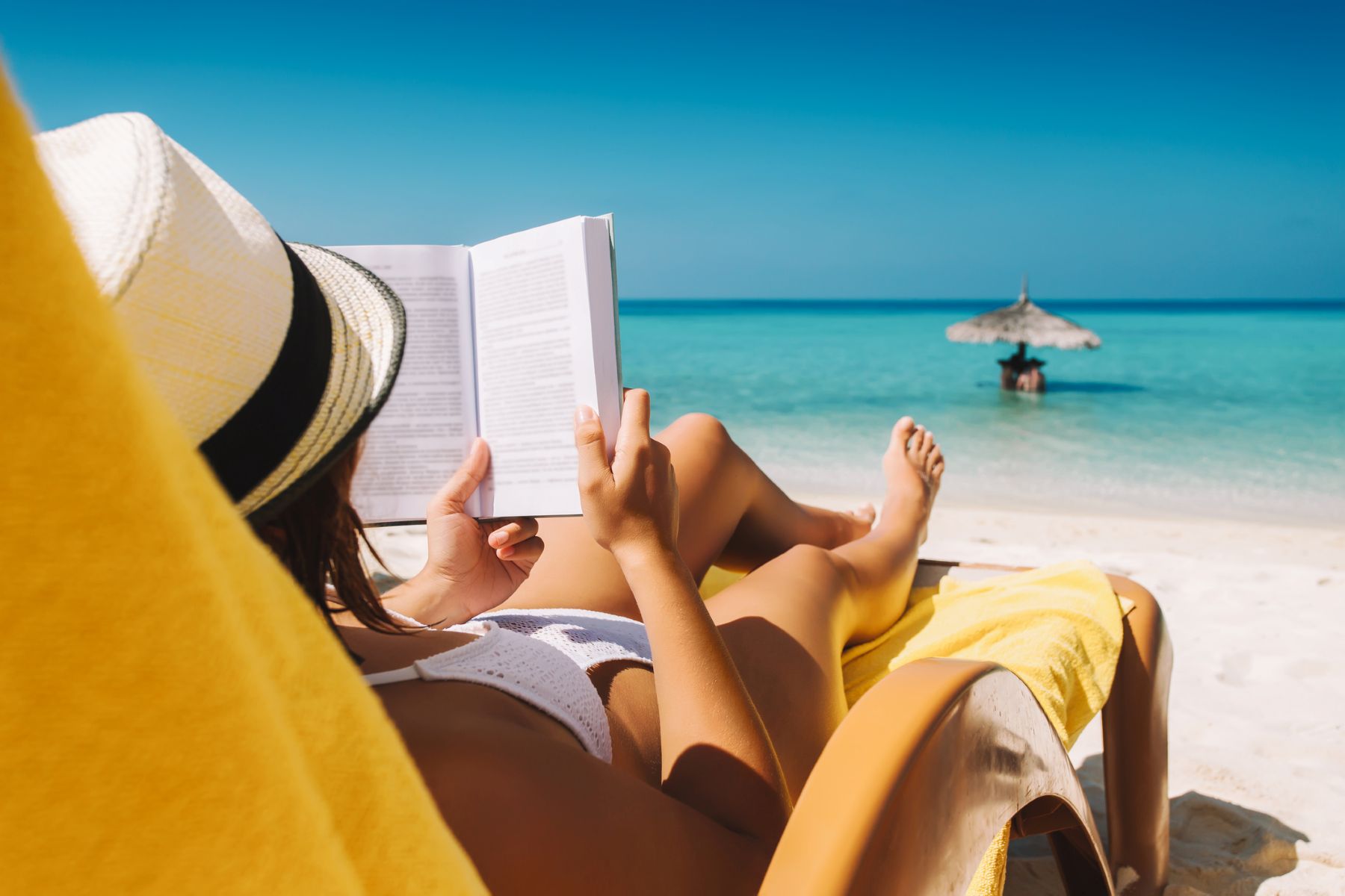 Mujer en hamaca leyendo libro en la playa