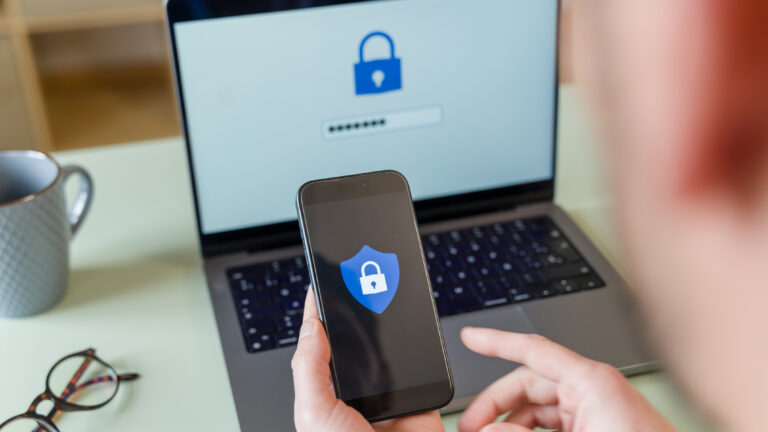 Ciberseguridad. Programador que protege los datos con autenticación de dos factores utilizando una computadora portátil y un teléfono inteligente. Foto: istock