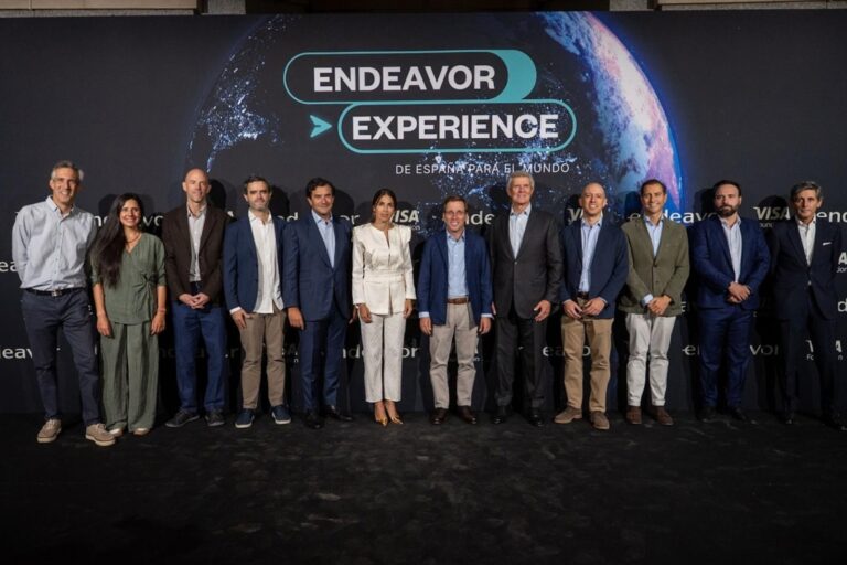 Foto de grupo en Endeavor Experience 2026, celebrado en el Teatro Real de Madrid, con el alcalde Jose Luis Martinez-Almeida en el centro junto a directivos y emprendedores. Al fondo, el lema del evento: De Espana para el mundo
