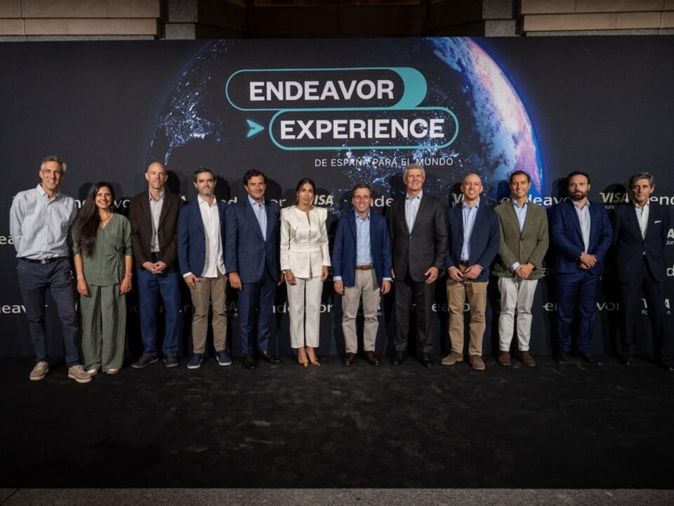 Foto de grupo en Endeavor Experience 2026, celebrado en el Teatro Real de Madrid, con el alcalde Jose Luis Martinez-Almeida en el centro junto a directivos y emprendedores. Al fondo, el lema del evento: De Espana para el mundo