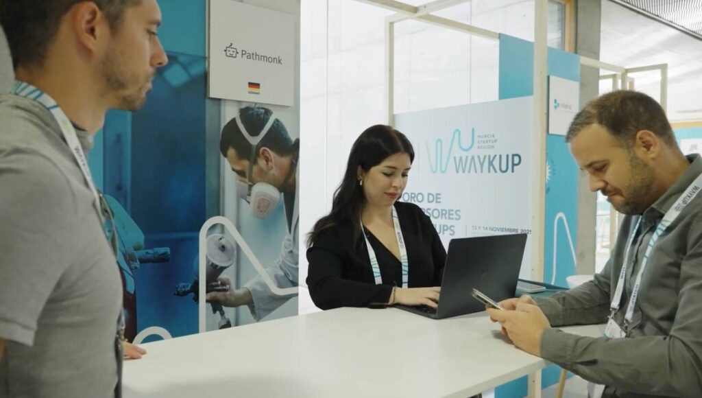WaykUp Forum Murcia 2025. Mujer en un mostrador entregando credenciales