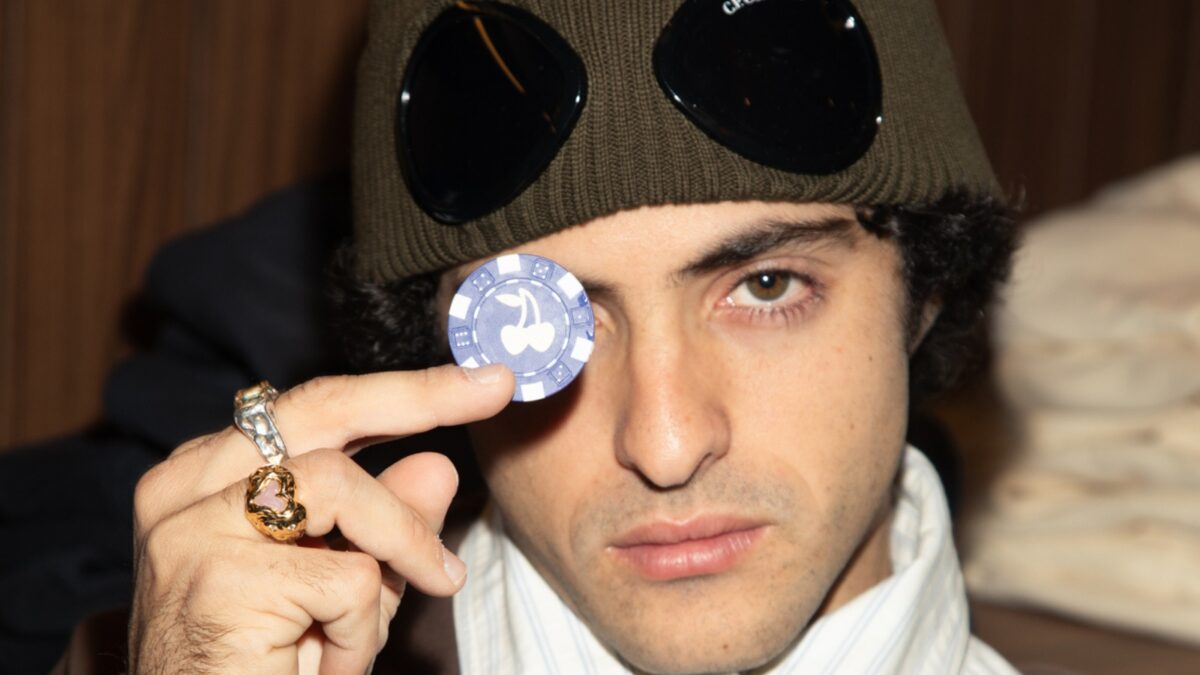 Bruno Casanovas, cofundador de Nude Project, sostiene una ficha de poker con el logo de cerezas de la marca frente a su ojo