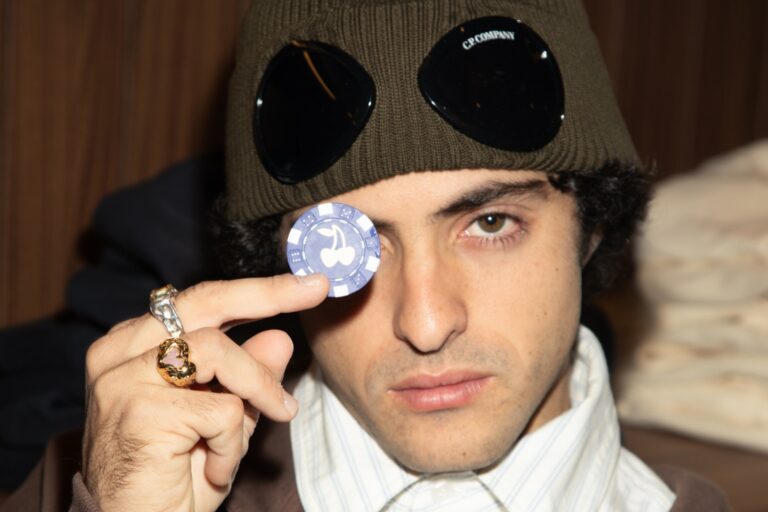 Bruno Casanovas, cofundador de Nude Project, sostiene una ficha de poker con el logo de cerezas de la marca frente a su ojo