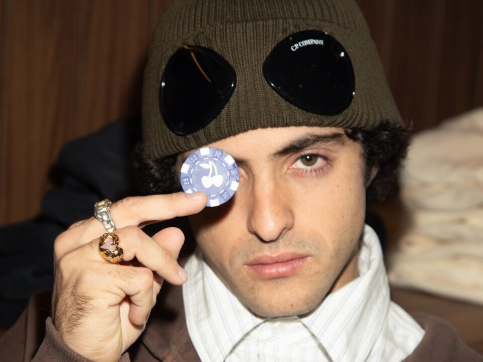 Bruno Casanovas, cofundador de Nude Project, sostiene una ficha de poker con el logo de cerezas de la marca frente a su ojo