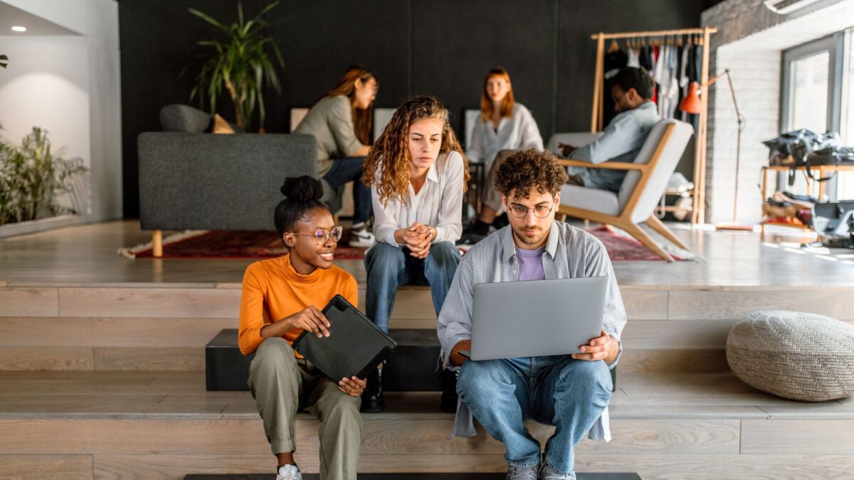 Grupo de jóvenes de la Generación Z usando un portátil en una oficina moderna