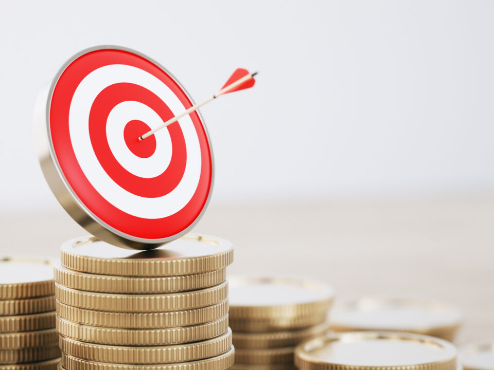 Objetivo con flecha y pilas de monedas, objetivo financiero y concepto de éxito de inversión.