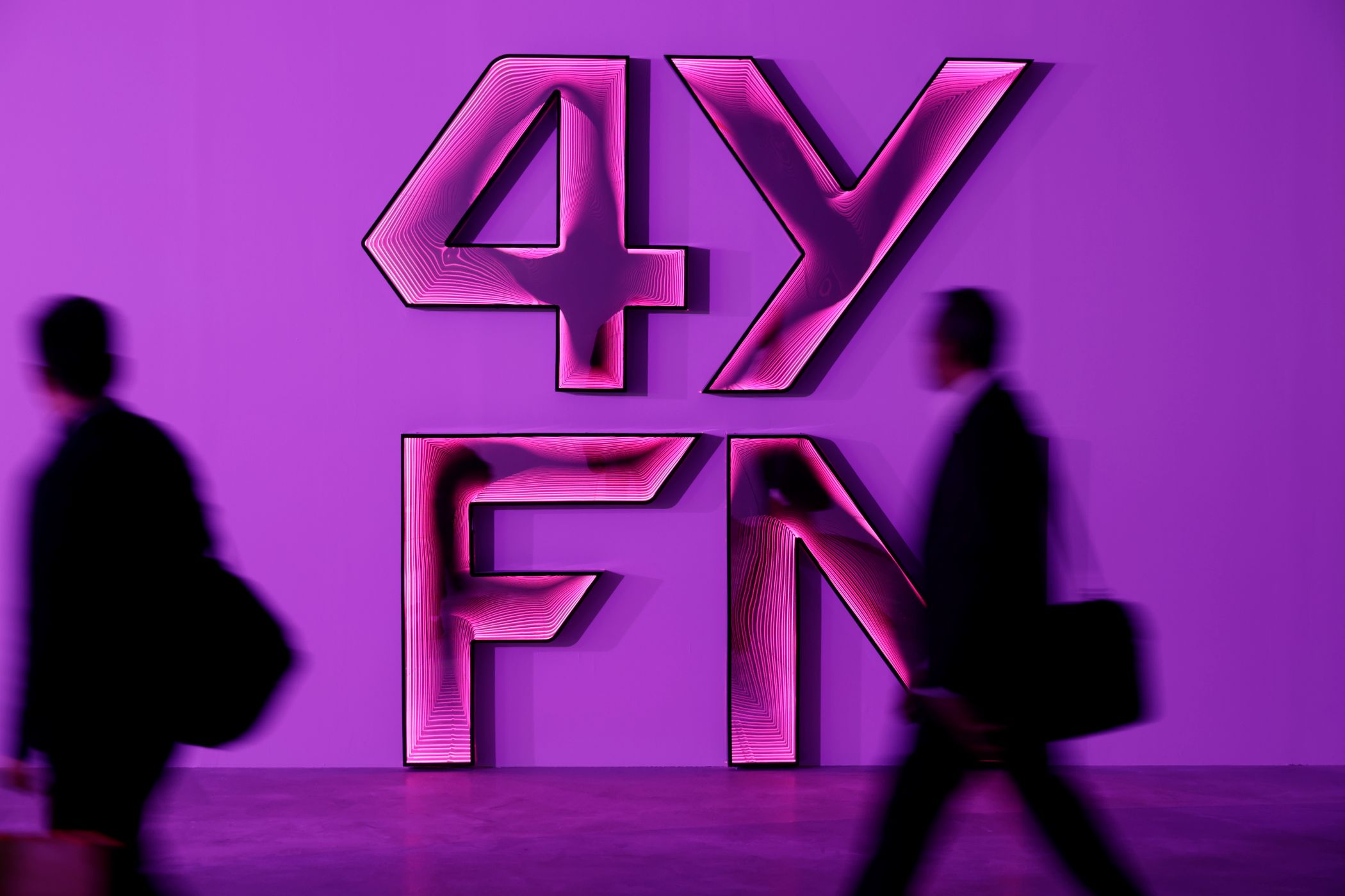 Visitantes del 4YFN caminando junto al logo del encuentro