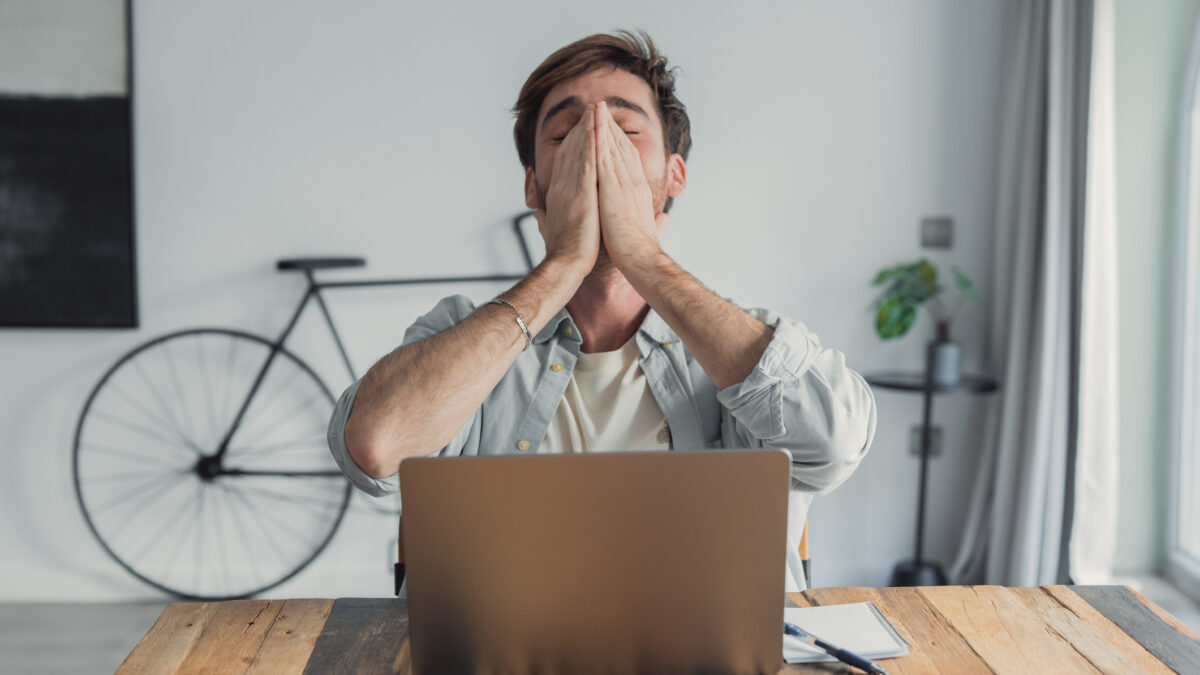 Hombre que se siente abrumado y estresado trabajando desde casa