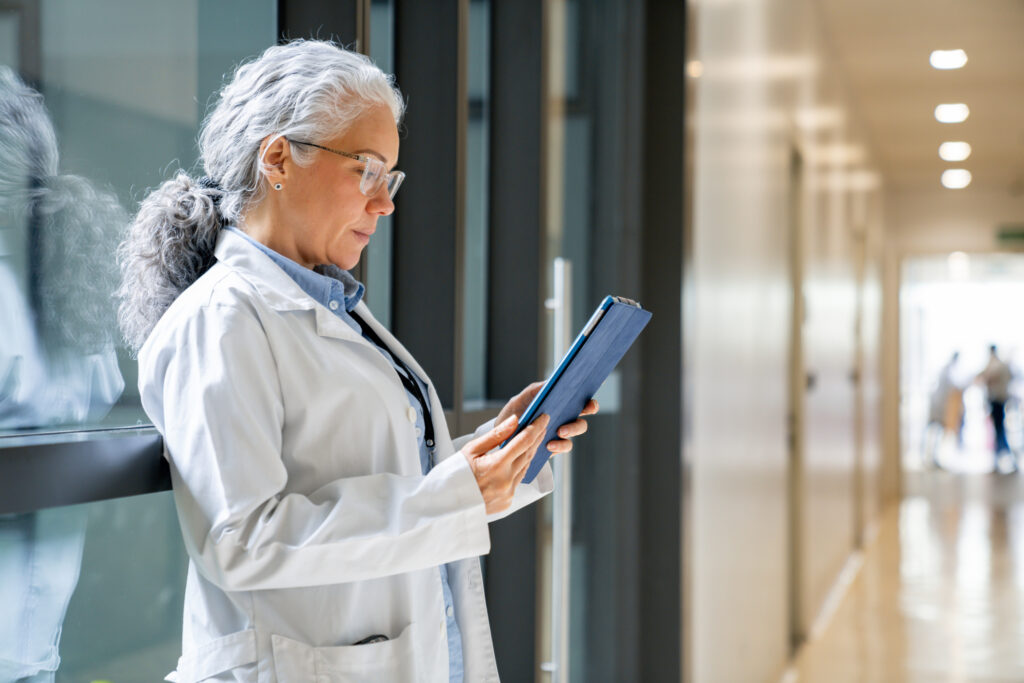 Doctora en el pasillo de un centro de salud leyendo un informe. Foto: iStock