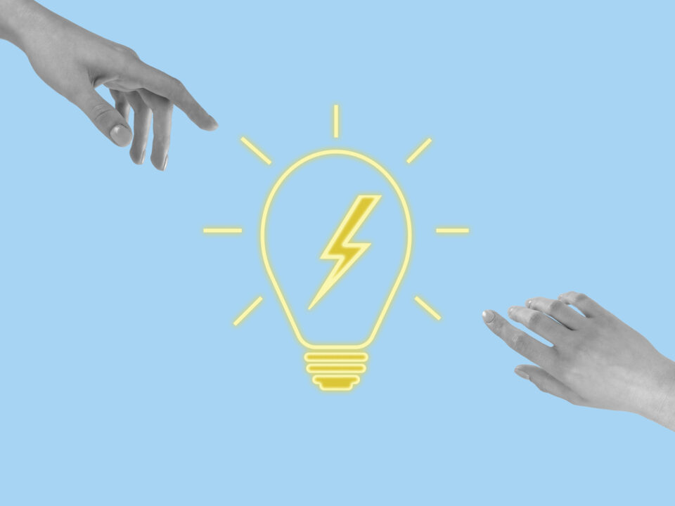 Manos que alcanzan la bombilla brillante. Lluvia de ideas, trabajo en equipo, colaboración, búsqueda y generación de soluciones o concepto de buena idea sobre fondo azul. Foto: istock