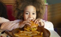 Niña comiendo una hamburguesa