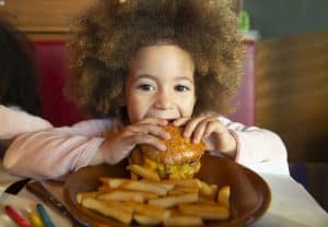 Niña comiendo una hamburguesa