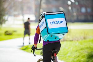 Delivery. Woman with big food delivery backpack
