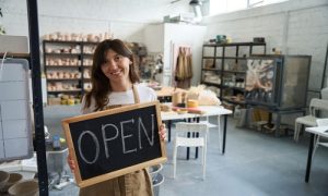 Emprendedora en la puerta de entrada de su negocio