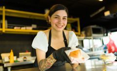 Camarera sirviendo una hamburguesa gourmet