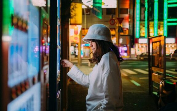 Chica utilizando una máquina de vending