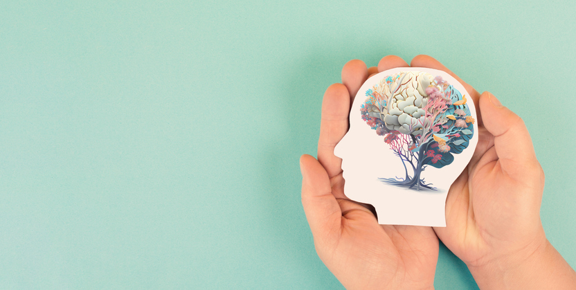 salud mental. manos sosteniendo una cabeza humana con un cerebro con flores