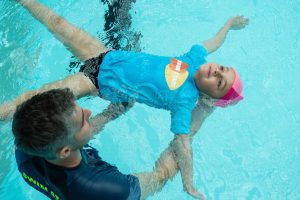 Monitor y niño en la piscina