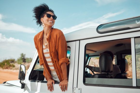 emprender en turismo. mujer sacando la cabeza por una ventanilla en vacaciones