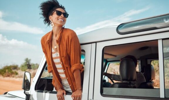 emprender en turismo. mujer sacando la cabeza por una ventanilla en vacaciones