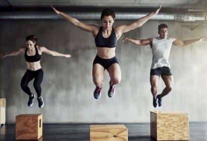 Dos chicas y un chico saltando en un gimnasio